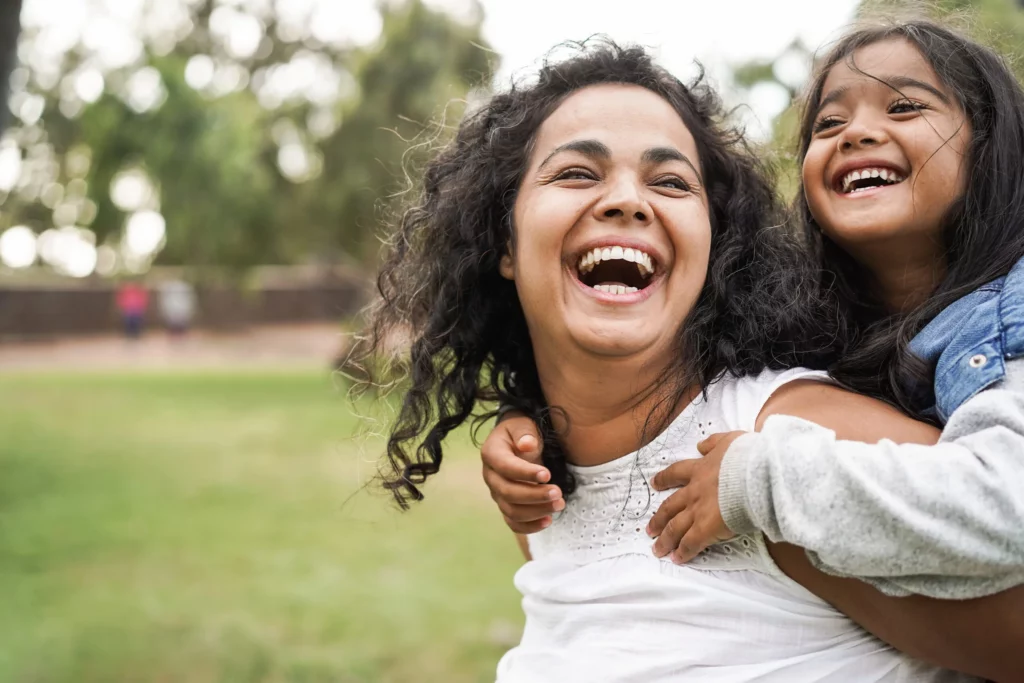 Happy indian mother having fun with her daughter outdoor - Famil